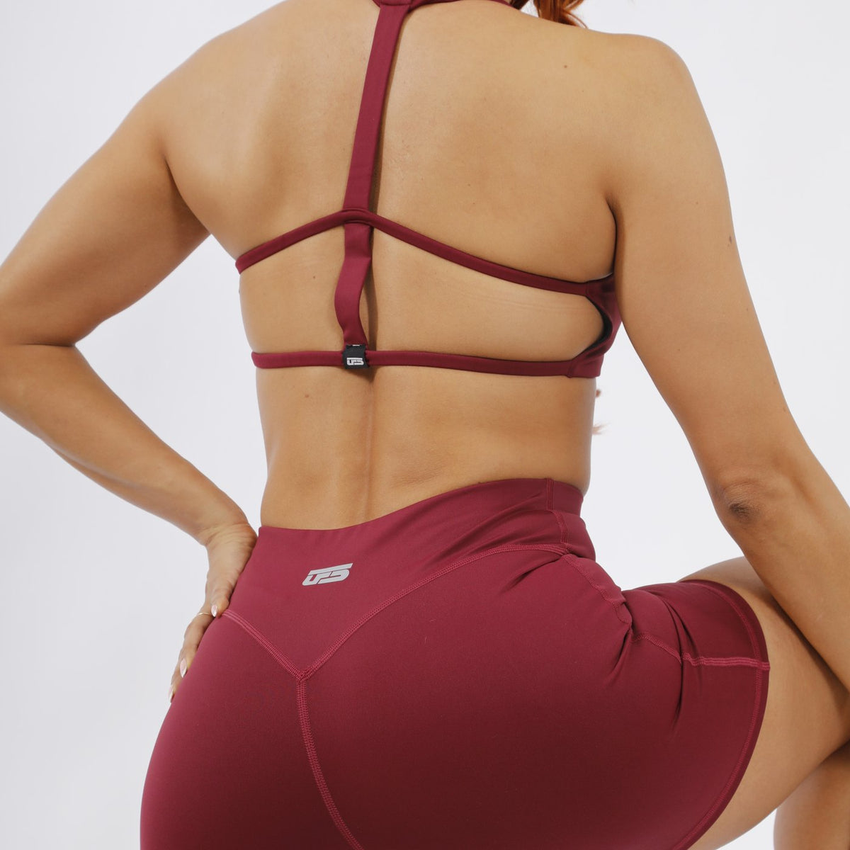 Espalda de mujer con top y biker vinotinto UFSport