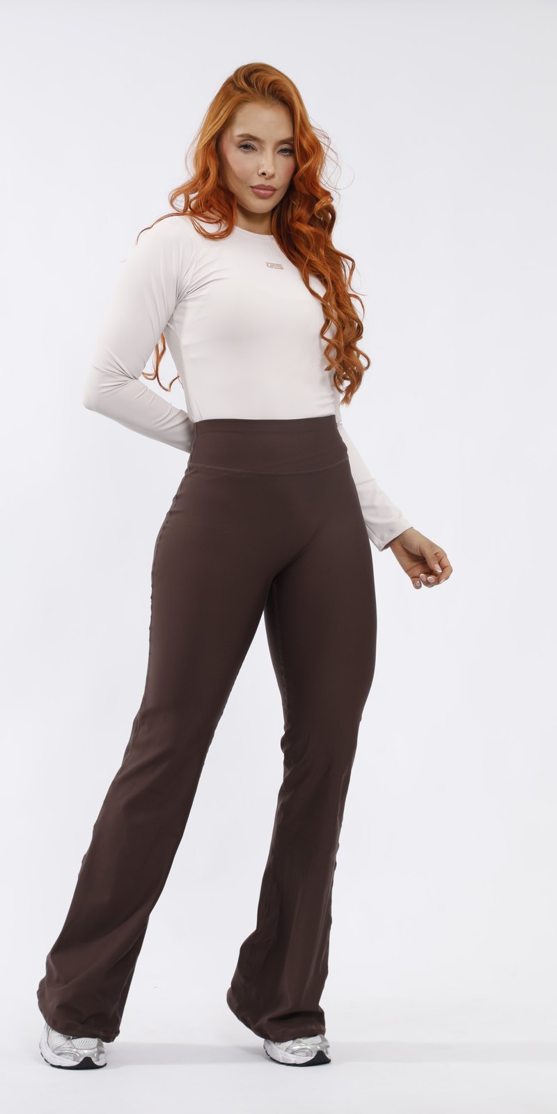 Mujer con leggins bota campana café y top crema UFSport